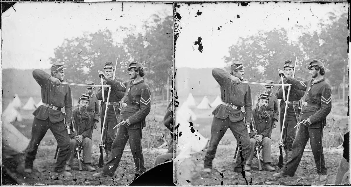Two Union soldiers engaged in mock swordfighting.